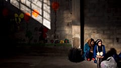 Two women wait to receive aid in Greece.