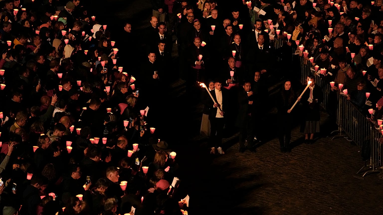 Faithful hold the cross as they take part in the Way of the Cross  procession at the Colosseum on Good Friday, in Rome, Friday, April 7, 2023