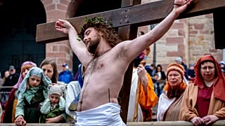 Ein Laienschauspieler wird während der Karfreitagsprozession in Bensheim, Deutschland ans Kreuz geschlagen.