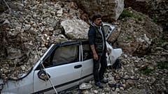 Cuma Zobi steht vor sienem verschüttetrten Auto.