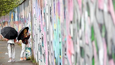 Tourists sign the “peace walls” that still separate some nationalist and unionist neighborhoods in west Belfast, Northern Ireland, Wednesday, April 5, 2023.