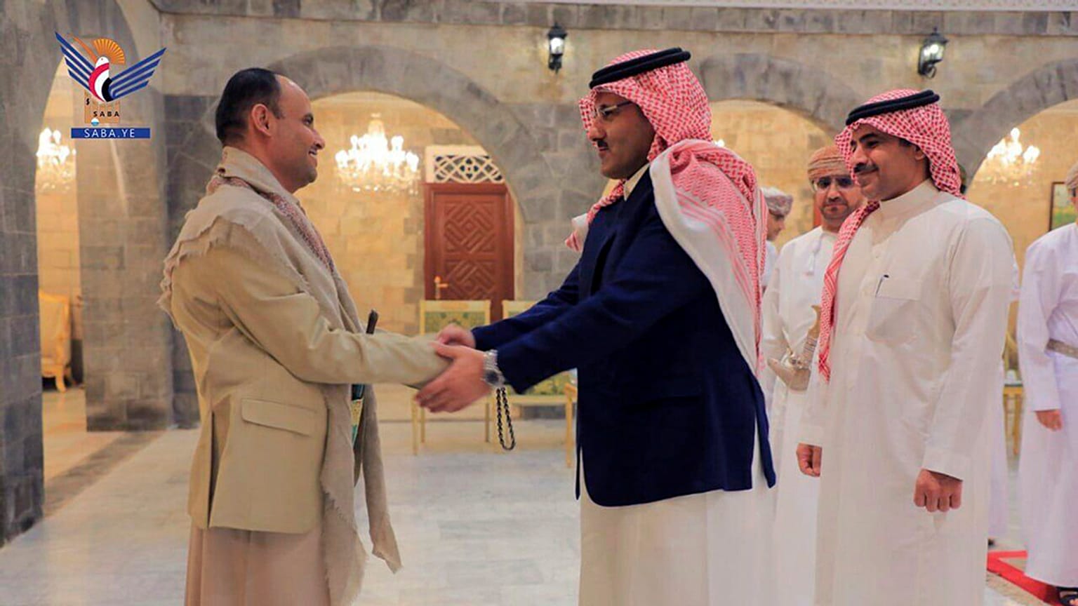 El jefe del consejo político supremo de los hutíes, Mahdi al-Mashat (izquierda), estrecha la mano del embajador de Arabia Saudí en Yemen, Mohammed bin Saeed Al-Jaber, en Saná,