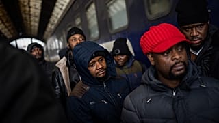 Ukrajnában tanuló afrikai diákok várják a vonatot az ukrajnai Lviv pályaudvarán három nappal azután, hogy Oroszország megszállta Ukrajnát