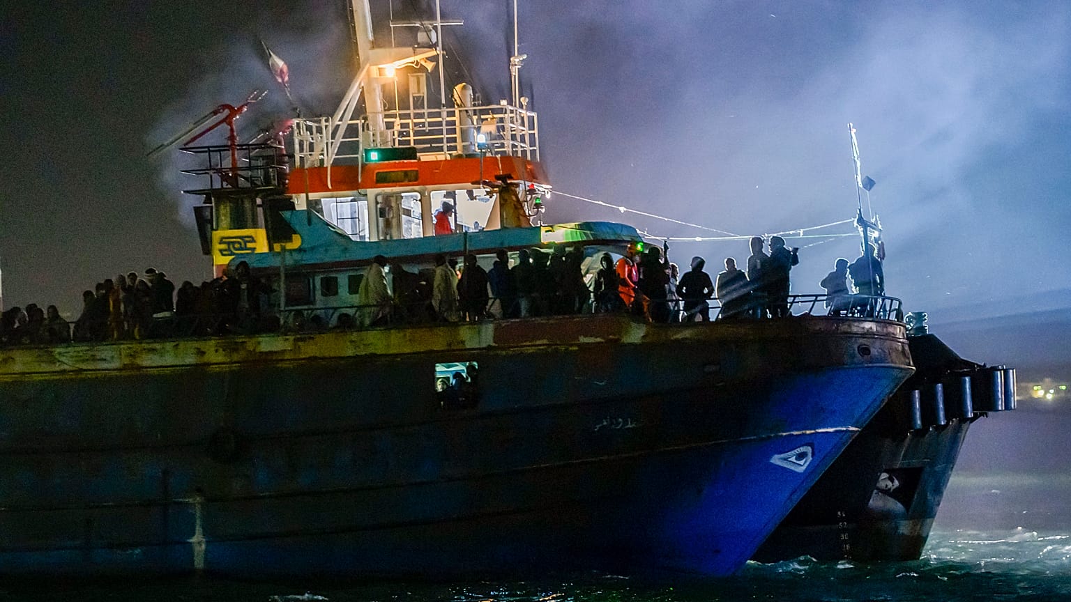 A fishing boat with some 500 migrants enters the southern Italian port of Crotone, early Saturday, March 11, 2023. 