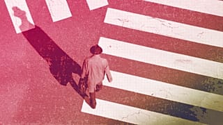 A man walks along a pedestrian crossing, January 2022