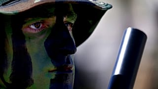 A soldier with camouflage on his face.