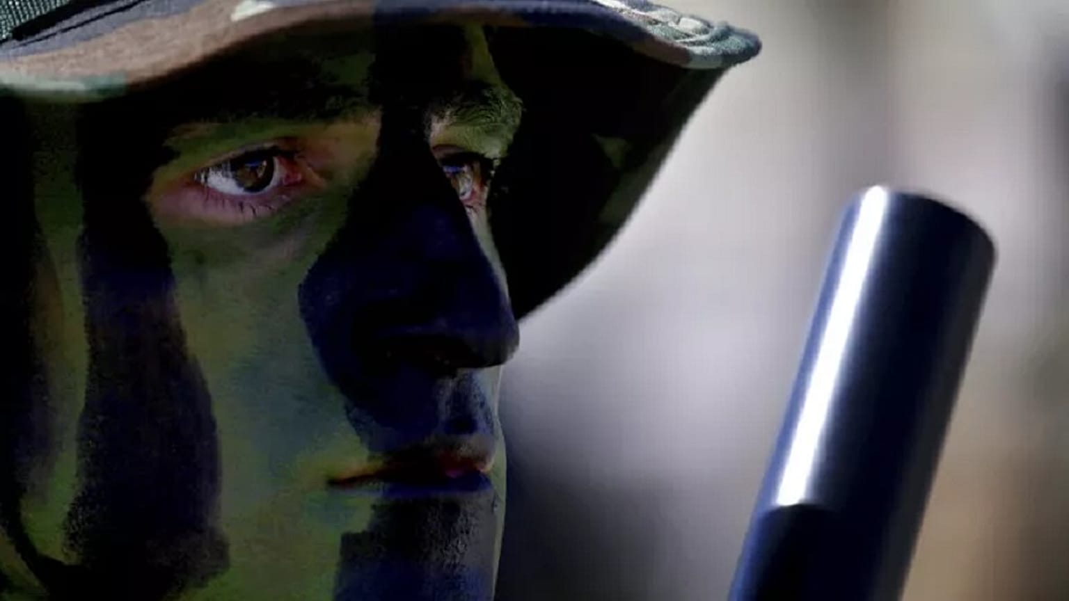 A soldier with camouflage on his face.   -  