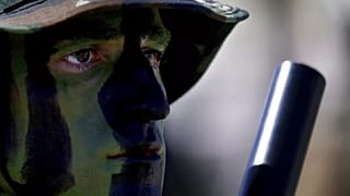 A soldier with camouflage on his face. -