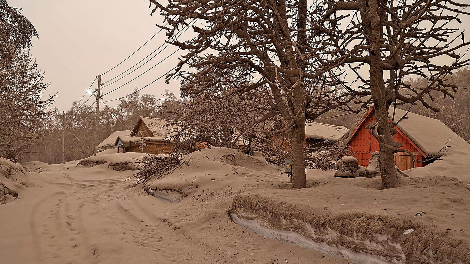 In this photo provided by the Russian Academy of Sciences' Volcanology Institute, volcanic ash covers the ground and houses after the Shiveluch volcano's eruption.