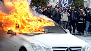 Protesters watch a burning car during a demonstration in Rennes, western France.