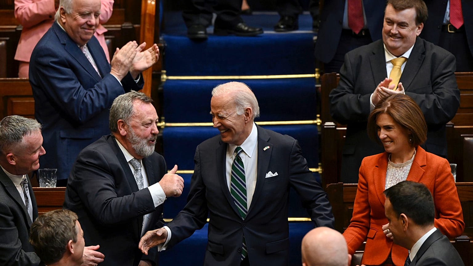 Members of parliament stand as President Joe Biden walks down the steps before he addresses members of the Irish parliament at Leinster House in Dublin, Thursday, April 13.