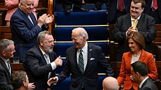 Members of parliament stand as President Joe Biden walks down the steps before he addresses members of the Irish parliament at Leinster House in Dublin, Thursday, April 13.