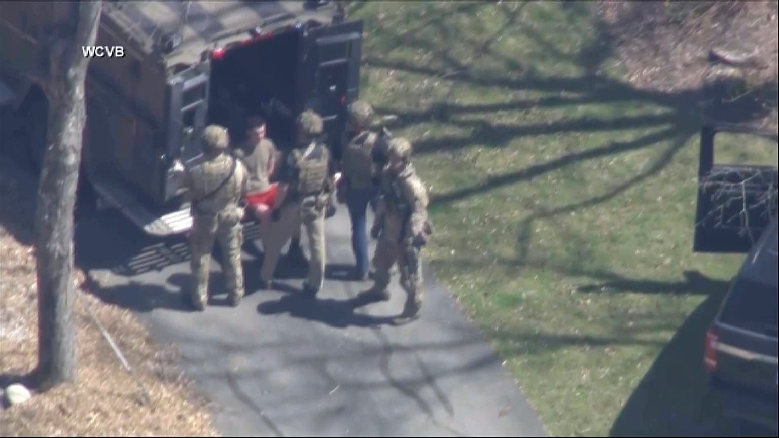 This image made from video provided by WCVB-TV, shows Jack Teixeira, in T-shirt and shorts, being taken into custody by armed tactical agents on Thursday, April 13, 2023,.