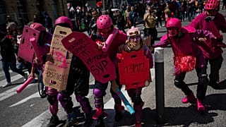 Des manifestants déguisés en policiers anti-émeute français participent à une manifestation à Marseille, dans le sud de la France, le jeudi 13 avril 2023.