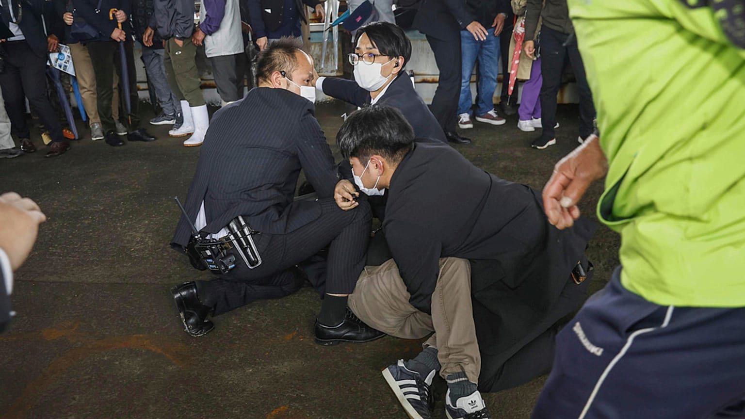 A man, on the ground, who threw what appeared to be a smoke bomb, is caught at a port in Wakayama, western Japan Saturday, April 15, 2023