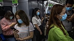 Maszkot viselő emberek a pekingi metrón