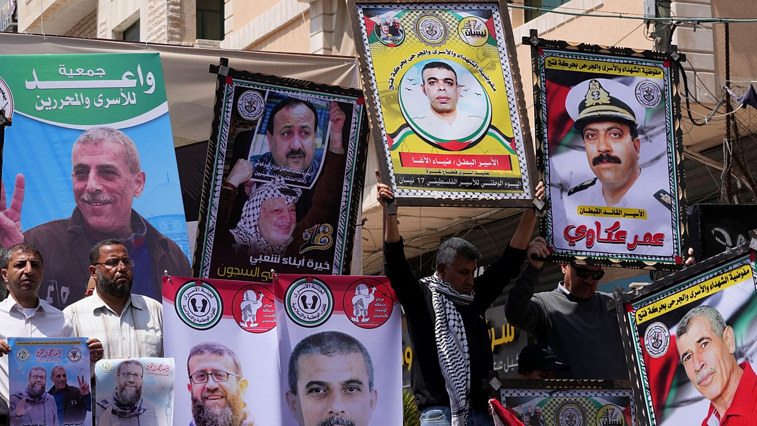المشاركون في فعالية يوم الأسير يرفعون صوراً للأسرى الفلسطينيين 