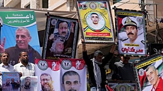 المشاركون في فعالية يوم الأسير يرفعون صوراً للأسرى الفلسطينيين