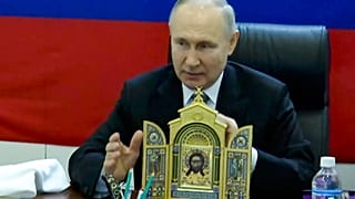 На кадрах, распространенных кремлевским пулом, президент России Владимир Путин показывает икону перед посещением одного из штабов российских войск.