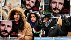 أشخاص يحملون لافتات تطالب بالإفراج عن عامل الإغاثة البلجيكي أوليفييه فانديكاستيل، المحتجز حاليًا في إيران، خلال مظاهرة في بروكسل، الأحد، 22 يناير/كانون الثاني 2023.