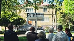 FILE: A man holds a sign reading "Putin Go Home" during a protest in front of the Russian Consulate in Mariehamn, Aland, Finland on June 1, 2022.