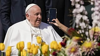 Pope Francis takes on AI - here pictured leaving his weekly general audience in St. Peter's Square, at the Vatican, while a woman holds a phone - 12 April 2023