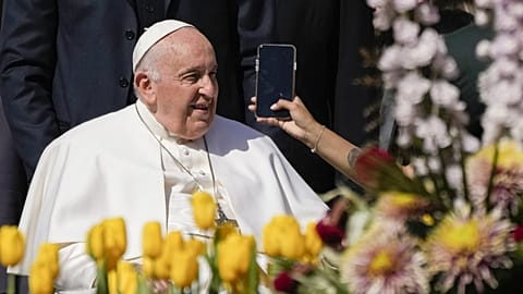 Pope Francis takes on AI - here pictured leaving his weekly general audience in St. Peter's Square, at the Vatican, while a woman holds a phone - 12 April 2023