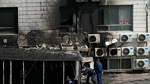 Investigators inspect burnt out corridor following a fire at a hospital in Beijing, Wednesday, April 19, 2023. 