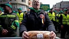 A woman holds a loaf of bread during a farmers' protest in front of the Representative Office of the European Commission in Bucharest, Romania, on, April 7, 2023. 