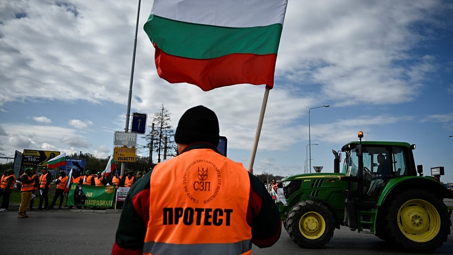 Un agriculteur agite un drapeau lors d'une action de blocage sur le Pont du Danube, qui marque la frontière entre la Roumanie et la Bulgarie. (29 mars 2023)