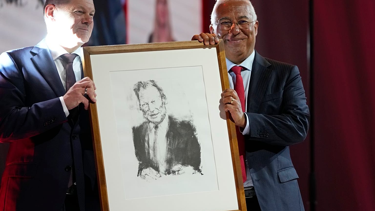 German Chancellor Olaf Scholz, left, presents Portuguese Prime Minister and Socialist Party Secretary General Antonio with a portrait of Willy Brandt.