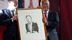 German Chancellor Olaf Scholz, left, presents Portuguese Prime Minister and Socialist Party Secretary General Antonio with a portrait of Willy Brandt.