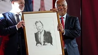 German Chancellor Olaf Scholz, left, presents Portuguese Prime Minister and Socialist Party Secretary General Antonio with a portrait of Willy Brandt.