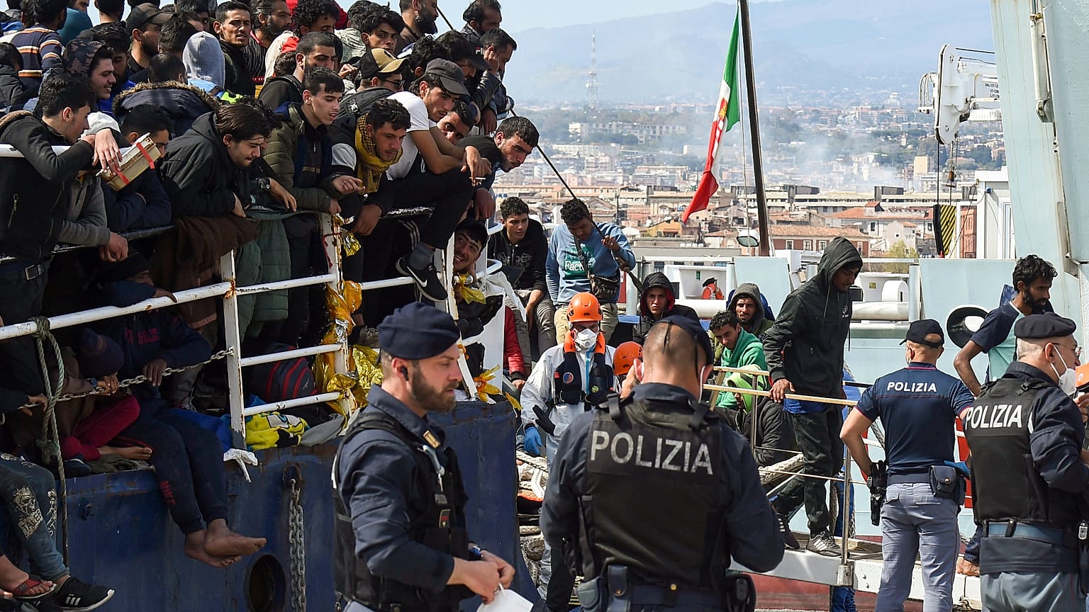Migranten gehen von Bord eines Schiffes im Hafen der italienischen Stadt Catania