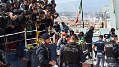 Migranten gehen von Bord eines Schiffes im Hafen der italienischen Stadt Catania