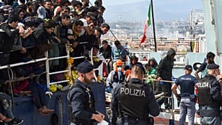 Migrantes a desembarcarem de um navio, no porto de Catânia, no passado dia 12