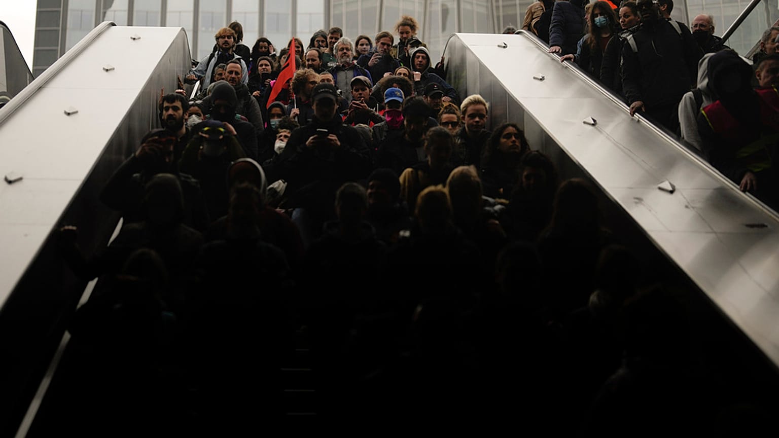 Demonstrators ride an escalator as they stage a protest against the pension reforms next to the Euronext Paris building at La Defense business district in Paris, Thursday.