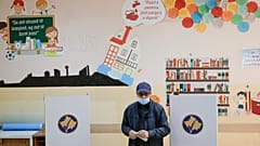 Un hombre sostiene su papeleta en las elecciones municipales de Pristina, capital de Kosovo, el domingo 14 de noviembre de 2021.