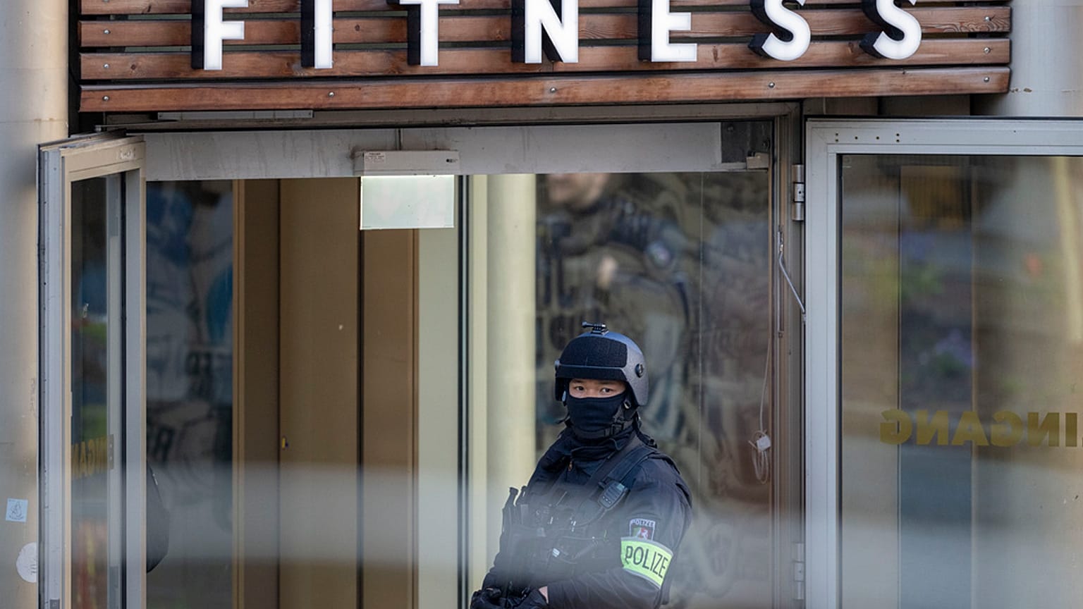 Polizeibeamter steht vor dem Fitness-Studio in Duisburg, in dem die Messerattacke stattfand