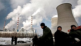 Munkások egy széntüzelésű erőmű mellett az északkelet-kínai Csangcsunban, Csilin tartományban.