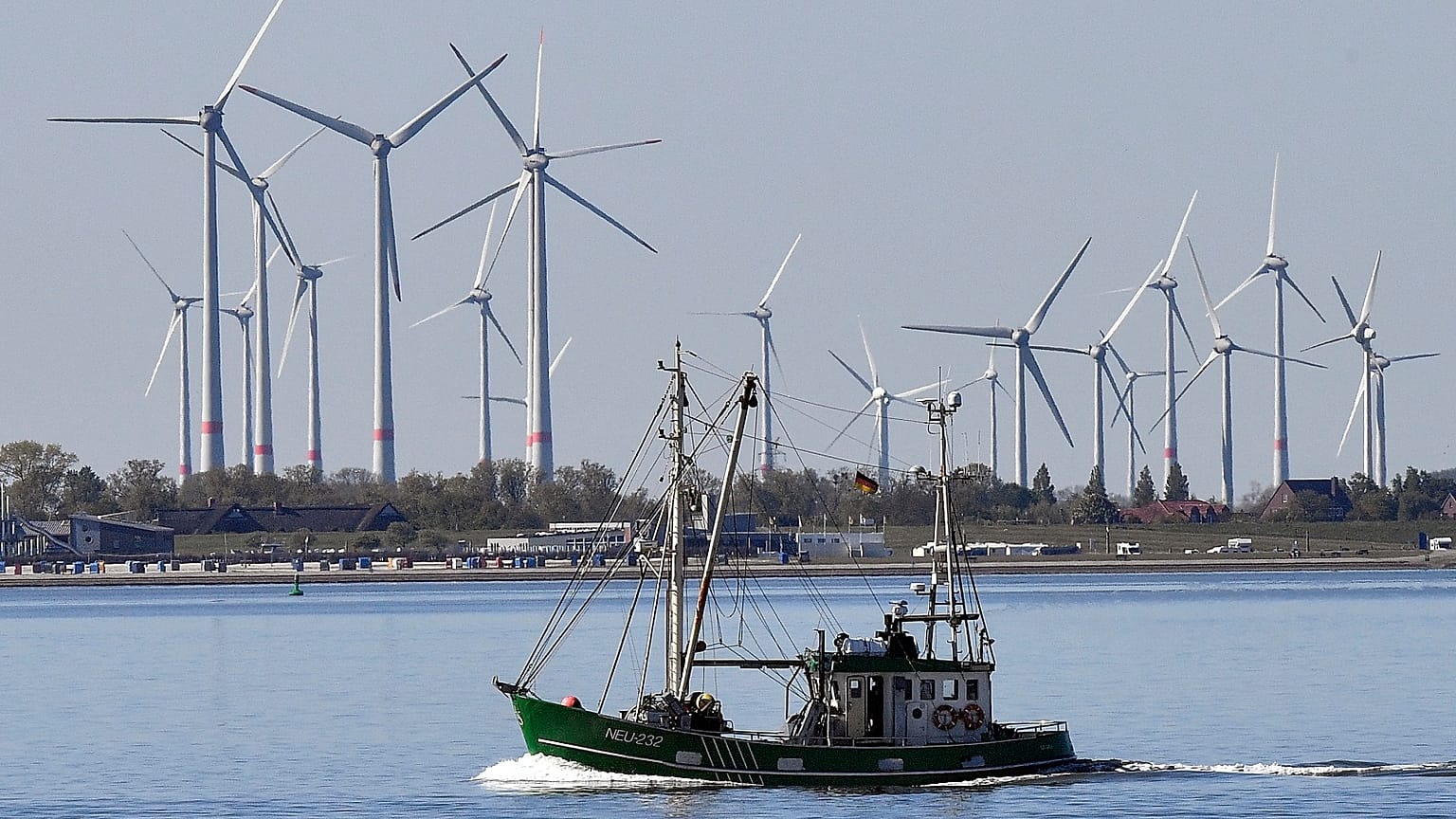 A fisher boat passes wind turbines between the island Langeoog and Bensersiel at the North Sea coast in Germany, on May 15, 2019