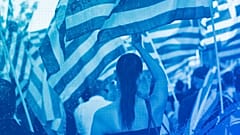 A supporter of the extreme far-right Golden Dawn political party waves a Greek flag during a pre-election rally, in Athens, September 2015