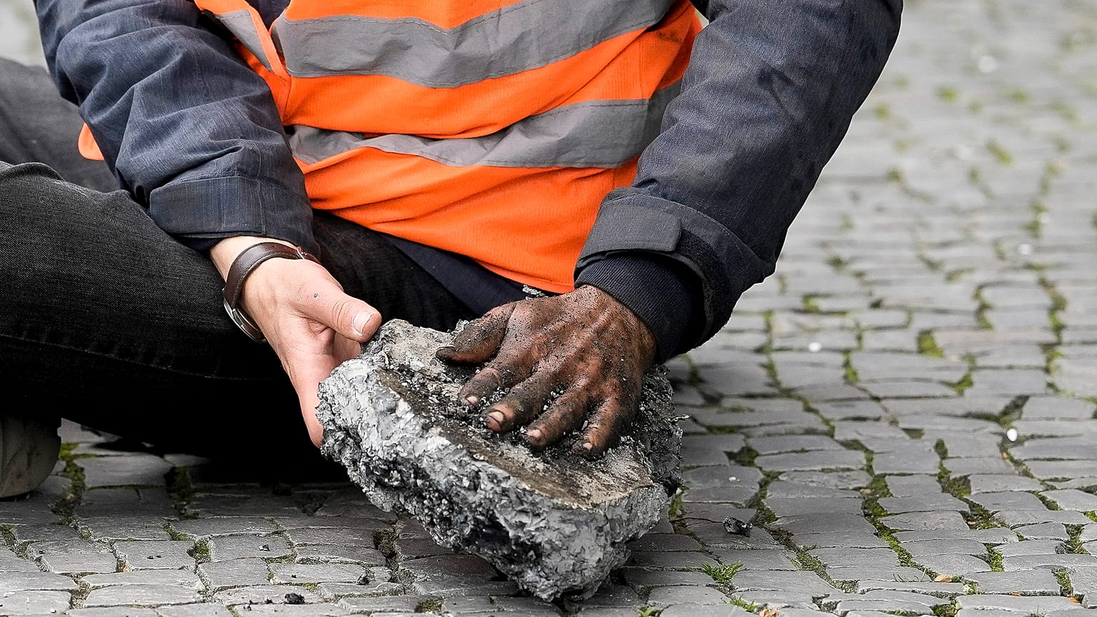 Ein Klimaaktivist musste mit einem Stück Straße befreit werden