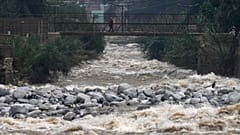 A woman walks on a bridge over the Rimac River, a day ahead of World Water Day.