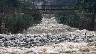 A woman walks on a bridge over the Rimac River, a day ahead of World Water Day.