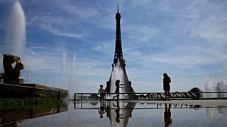 ARCHIVO - La gente se refresca cerca de las fuentes de los jardines de Trocadero en París, Francia, el miércoles 18 de mayo de 2022.