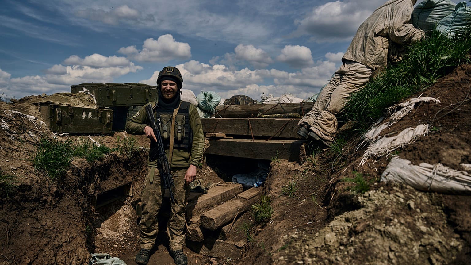 A Ukrainian soldier smiles standing in a trench on the frontline in the village of New York, Donetsk region, Ukraine, Monday, April 24, 2023.