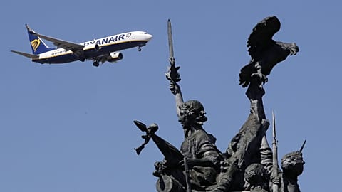 A Ryanair airplane approaching landing at Lisbon airport flies past the Monument to the Heroes of the Peninsular War, in the foreground, Aug. 21, 2019.
