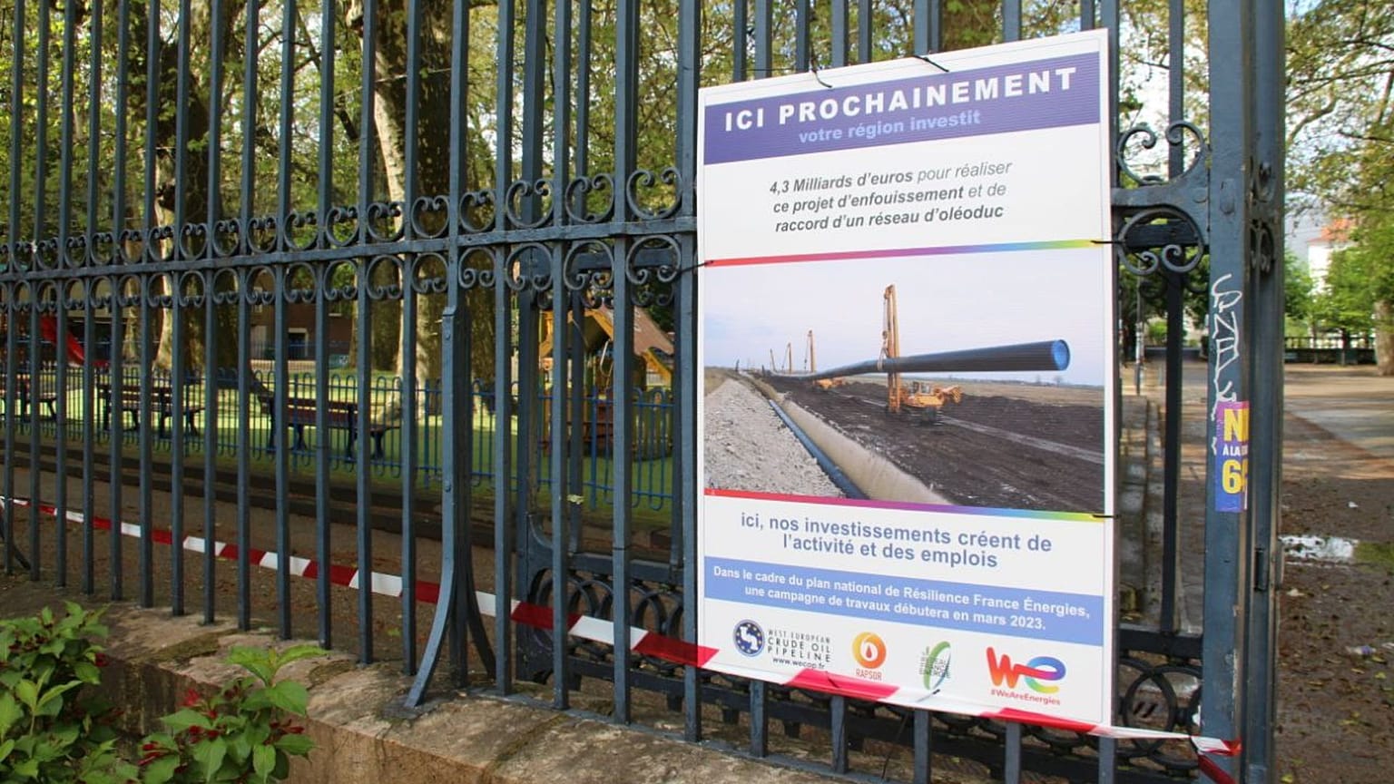Panneau annonçant le faux passage d'un oléoduc sous un parc public à Grenoble.