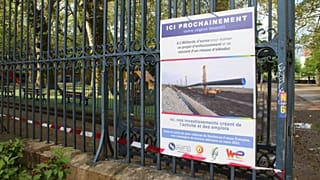 Panneau annonçant le faux passage d'un oléoduc sous un parc public à Grenoble.